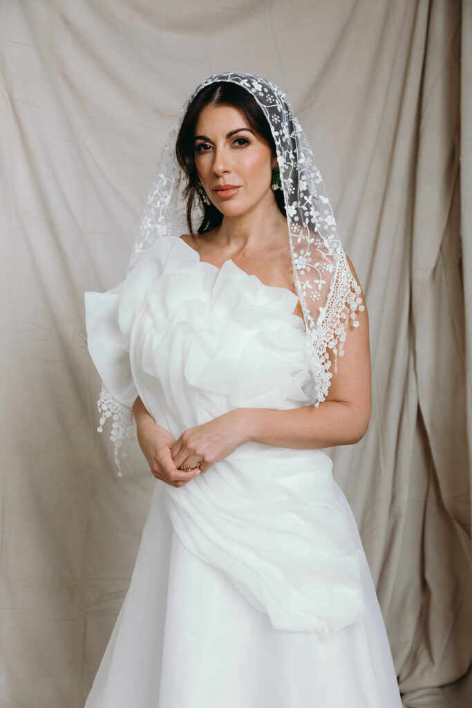Bride wearing a sculptural wedding gown and veil during an editorial wedding
